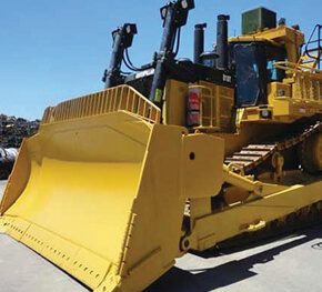 Large CAT dozer with wide front blade parked on a mine site.